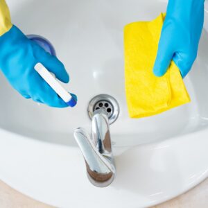 Hands with protection gloves cleaning a bathroom